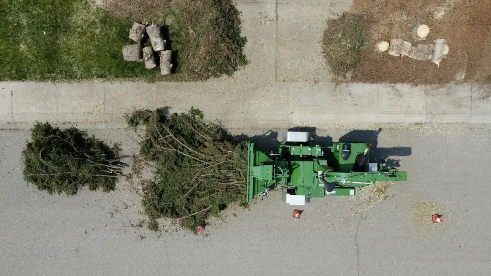 Broyeur de végétaux transformant des branches de taille en broyat