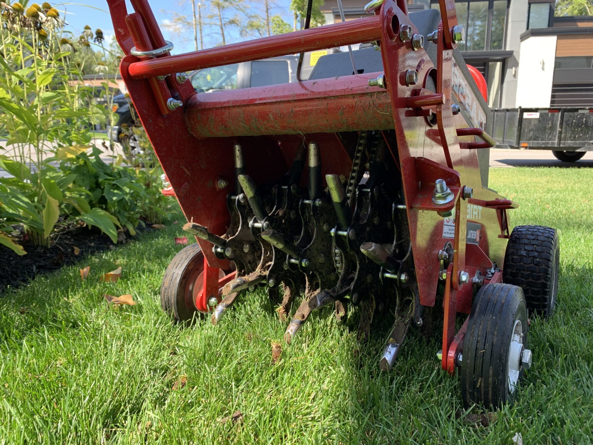 Machine carotteuse professionnelle en action sur gazon pour aération du sol